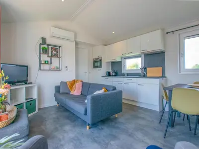 a living room with a blue couch and a kitchen at Grote Karekiet 24-30 in Breukelen