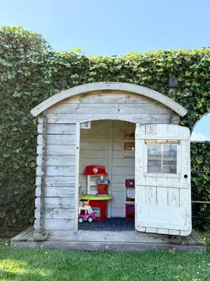 a wooden play house with a door in the grass at NEW - Private Residence with Sauna - on a lake near Amsterdam in Vinkeveen
