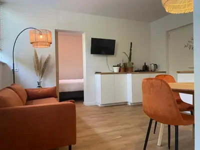 a living room with a couch and a table with chairs at Northgo apartment in Noordwijk