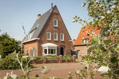 a brick house with a gambrel roof at Vakantiehuis Zeevonk in Bergen aan Zee