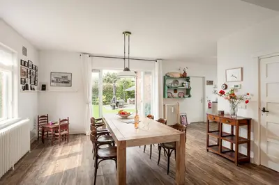 a kitchen and dining room with a table and chairs at Vakantiehuis Zeevonk in Bergen aan Zee