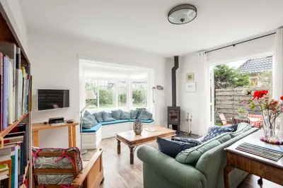 a living room with two couches and a window at Vakantiehuis Zeevonk in Bergen aan Zee