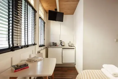 a room with a table and a kitchen with a bed at New! Private Authentic Apartment In City Centre! in Amsterdam