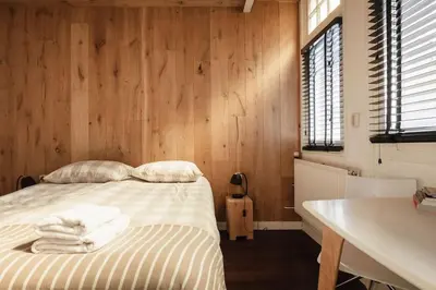 a bedroom with a bed with wooden walls and a sink at New! Private Authentic Apartment In City Centre! in Amsterdam