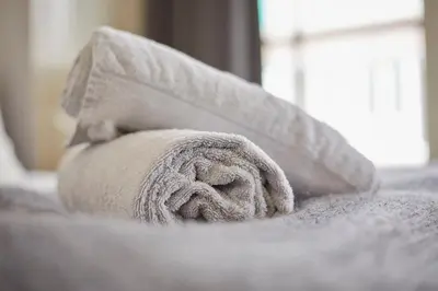 a roll of towels sitting on top of a bed at Modern Canal House Loft - City Center in Amsterdam