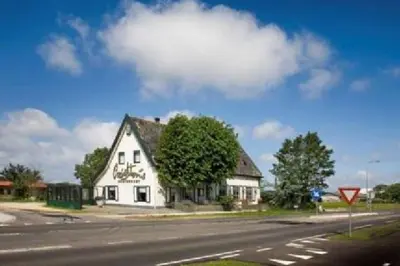 a white building on the side of a road at Chalet Egmond in Egmond aan den Hoef