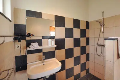 a bathroom with a sink and a shower with a mirror at Chalet Egmond in Egmond aan den Hoef