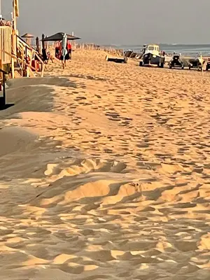a sandy beach with people and cars on it at Comfortable Room in Alkmaar