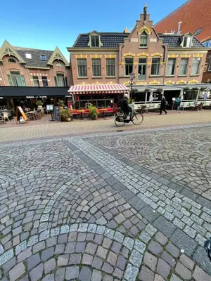 a person riding a bike on a brick street at Comfortable Room in Alkmaar