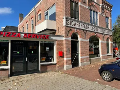a brick building with a pizza service sign on it at Comfortable Room in Alkmaar