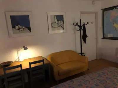 a living room with a table and a chair and a desk at Comfortable Room in Alkmaar