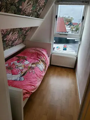 a small room with a bed and a window at Luxe vakantiehuisje in prachtige en rustgevende omgeving in Nieuwe-Niedorp