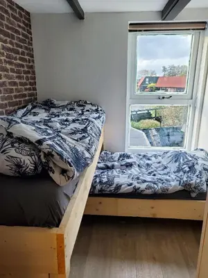 two beds in a room with a window at Luxe vakantiehuisje in prachtige en rustgevende omgeving in Nieuwe-Niedorp