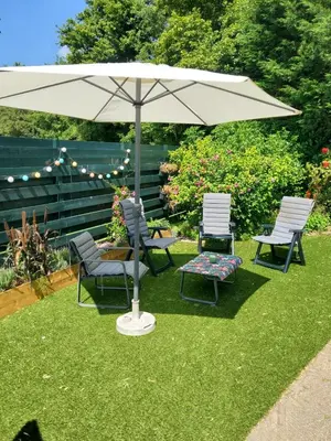 a patio with two chairs and an umbrella at Luxe vakantiehuisje in prachtige en rustgevende omgeving in Nieuwe-Niedorp