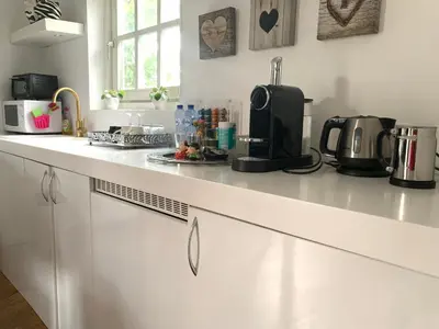 a white kitchen with a counter top with a coffee maker at Place To Be in Naarden
