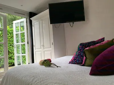 a stuffed animal on a bed with a television on the wall at Place To Be in Naarden