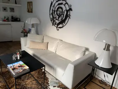a white couch in a living room with a table at Place To Be in Naarden