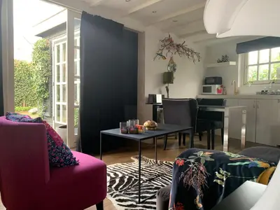 a living room with a red couch and a table at Place To Be in Naarden