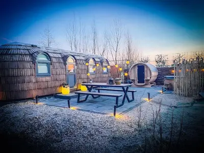 a patio with a picnic table in front of a building at Bed & Wellness Klein Knorrestein with private hottub and sauna and tandembike rental included in price in Almere