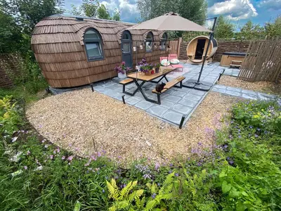 a backyard with a table and an umbrella at Bed & Wellness Klein Knorrestein with private hottub and sauna and tandembike rental included in price in Almere