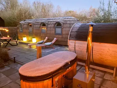a yurt with a bench and two chairs on a patio at Bed & Wellness Klein Knorrestein with private hottub and sauna and tandembike rental included in price in Almere