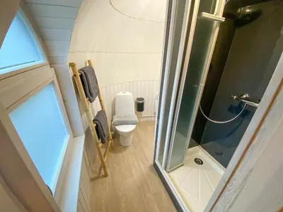 a small bathroom with a toilet and a shower at Bed & Wellness Klein Knorrestein with private hottub and sauna and tandembike rental included in price in Almere