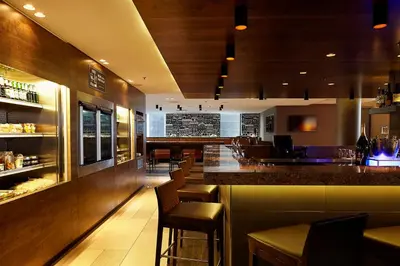 a bar in a restaurant with stools and a counter at Hyatt Place Amsterdam Airport in Hoofddorp
