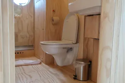 a bathroom with a toilet and a trash can at De Parel - Mystical spaces to discover! in Zeewolde