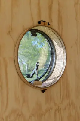 a round mirror on a wall with a window at De Parel - Mystical spaces to discover! in Zeewolde