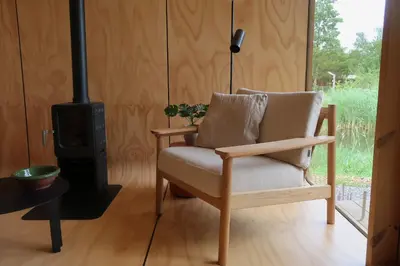 a chair in a room with a wood stove at De Parel - Mystical spaces to discover! in Zeewolde