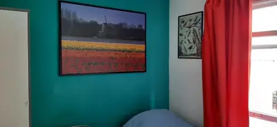 a bedroom with a green wall with a painting on the wall at NICOLE, not for parties, not a hotel, room with shared bathroom, no kitchen in Amsterdam