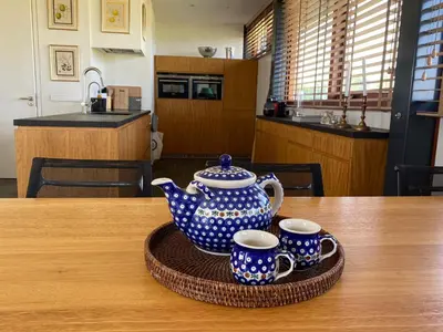 a tea pot and two cups sitting on a table at Hestar Husid, het luxe paardenhuis in Weesp