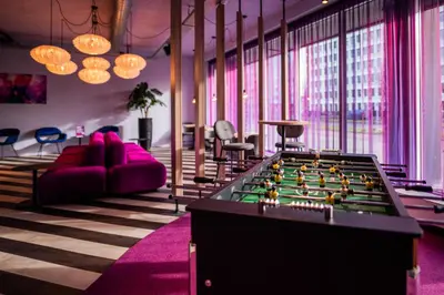 a living room with a foosball table and pink furniture at Hotel VIC in Leiden
