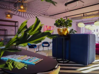 a table and chairs in a room with plants at Hotel VIC in Leiden