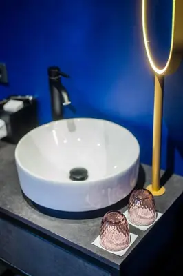 a white sink on a counter with two chocolate donuts at Hotel VIC in Leiden
