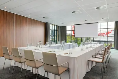 a large conference room with a long table and chairs at Corendon Amsterdam Schiphol Airport, a Tribute Portfolio Hotel in Badhoevedorp