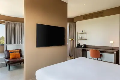a hotel room with a bed and a flat screen tv at Corendon Amsterdam Schiphol Airport, a Tribute Portfolio Hotel in Badhoevedorp
