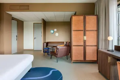 a hotel room with a bed and a couch at Corendon Amsterdam Schiphol Airport, a Tribute Portfolio Hotel in Badhoevedorp