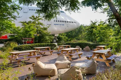 a group of picnic tables and chairs and an airplane at Corendon Amsterdam Schiphol Airport, a Tribute Portfolio Hotel in Badhoevedorp