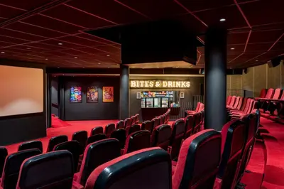 a cinema room with red chairs and a screen at Residence Inn by Marriott Amsterdam Schiphol Airport in Badhoevedorp