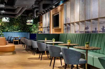 a restaurant with tables and chairs and plants at Residence Inn by Marriott Amsterdam Schiphol Airport in Badhoevedorp