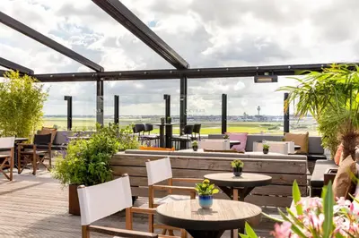 a restaurant with tables and chairs and windows at Residence Inn by Marriott Amsterdam Schiphol Airport in Badhoevedorp