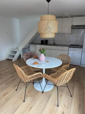 a white table and chairs in a kitchen at zilvermeeuw in Bergen aan Zee