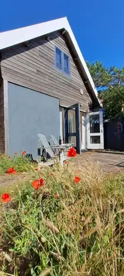 a garage with a bench in front of a house at zilvermeeuw in Bergen aan Zee