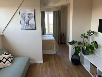 a small room with a bed and an elephant picture at Weltevreden in Noordwijk