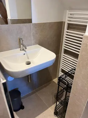 a bathroom with a white sink and a shelf at Weltevreden in Noordwijk