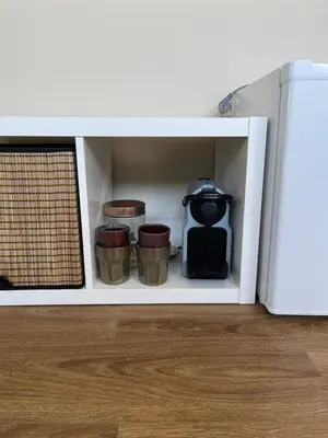 a white cabinet with three cups and a stove at Weltevreden in Noordwijk