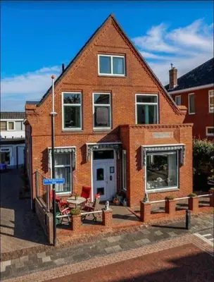 a brick house with a table and chairs in front of it at Weltevreden in Noordwijk