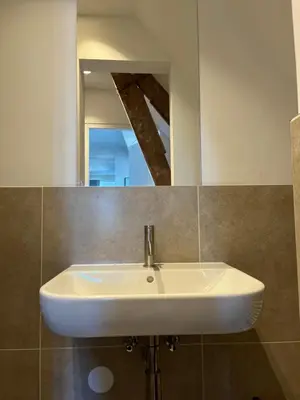 a white sink in a bathroom with a mirror at Weltevreden in Noordwijk