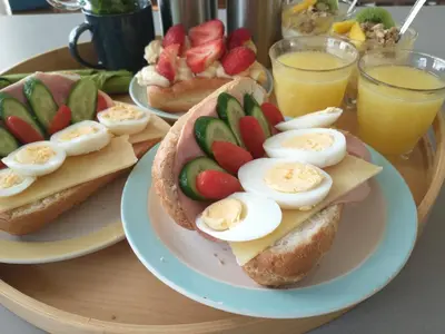 a plate of sandwiches with eggs and fruit on it at B&Bslapenopeeneiland in Kaag